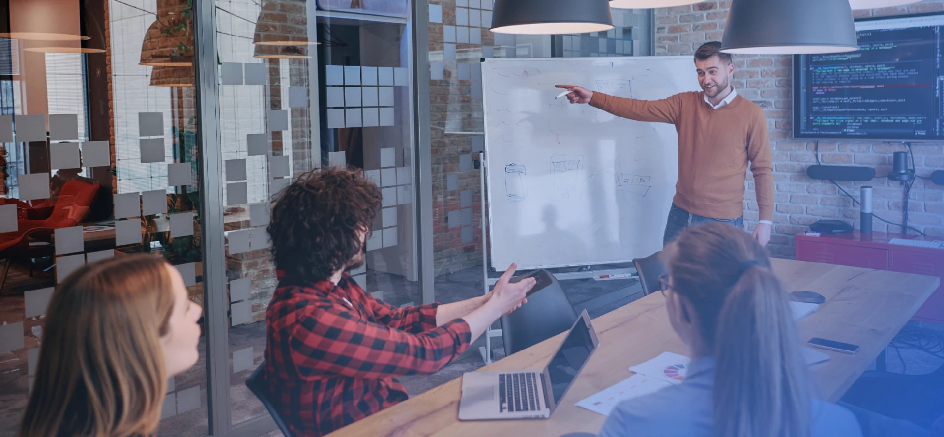 A software team discussing a product idea sketched on a whiteboard in a meeting room